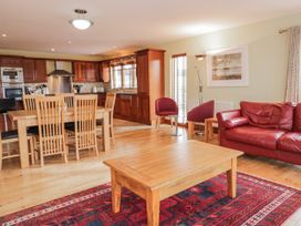 A dining area with a table and chairs and a living area with a sofa at Cashelrehine Falcarrheh