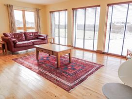 A living room with a sofa and table at Cashelrehine Falcarrheh