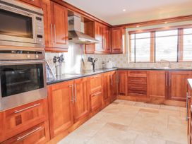 A kitchen with wooden cabinets and appliances at Cashelrehine Falcarrheh