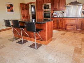 A kitchen with a countertop and bar stools at Cashelrehine in Falcarrheh