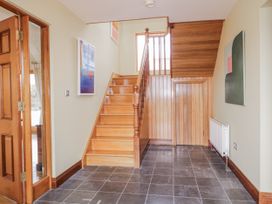 A hallway with a staircase and paintings at Cashelrehine Falcarrheh