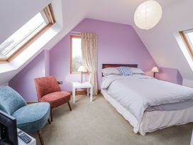 A bedroom with a bed and armchair at Cashelrehine, Falcarrheh