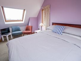 A bedroom with a bed and two chairs at Cashelrehine in Falcarrheh