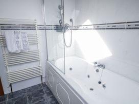 A bathroom with a bathtub and towel rack at Cashelrehine in Falcarrheh