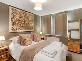 A bedroom with a double bed wooden bedside tables and a dresser with a mirror at Thorncliffe House in Pocklington
