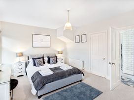 A bedroom with a double bed lamps on side tables and an open door leading to a bathroom at Thorncliffe House in Pocklington