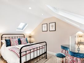 A bedroom with a metal frame bed and floral bedding under skylight windows at Thorncliffe House in Pocklington
