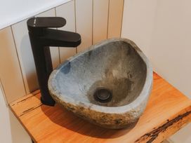 A stone sink with a black faucet on a wooden countertop at Glentress The Unfurl Cabin 2 doubles 1 twin in Glentress Forest Peebles
