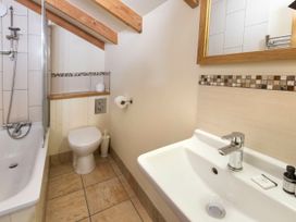 A bathroom with a bathtub a toilet a sink and a large mirror at Deerpark Classic Golden Oak Treehouse Deerpark Forest
