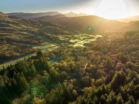 A valley with trees hills and a road under sunlight at Beddgelert Golden Oak - freshly inspired design in Beddgelert Eryri Snowdonia