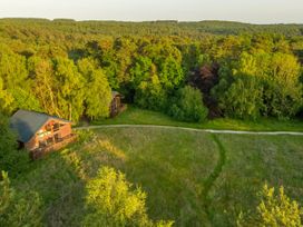 Two wooden cabins near a forest and grassy field at Keldy Classic Silver Birch in Keldy Forest