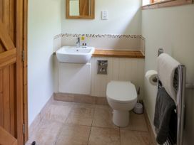 A bathroom with a sink toilet towel rack and wooden door at Strathyre Classic Golden Oak in Strathyre Ben Ledi