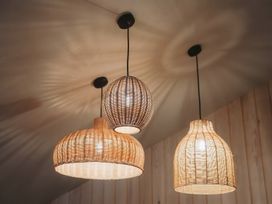 Three hanging pendant lights with woven lampshades in a room with wooden walls at Glentress The Unfurl Treehouse Glentress Forest Peebles