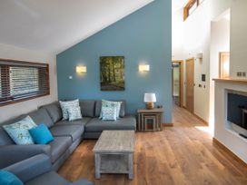 A living room with a grey sectional sofa and wooden coffee table at Ardgartan Argyll Silver Birch in Ardgartan Loch Long