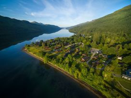 An aerial view of a residential area with houses near a body of water and forests at Ardgartan Argyll Silver Birch Ardgartan Loch Long