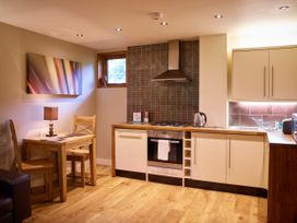 A kitchen with wooden flooring wooden table and chairs stove oven kettle and sink at Sherwood Forest Golden Oak in Sherwood Forest