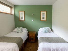 A bedroom with two single beds separated by a wooden nightstand and green accent wall at Deerpark Classic Golden Oak in Deerpark Forest