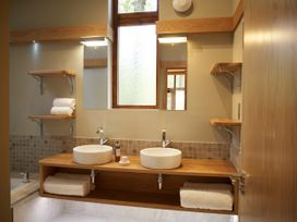 A bathroom with two round sinks on a wooden countertop and wooden shelves on the walls at Beddgelert Golden Oak Hideaway Beddgelert Eryri Snowdonia