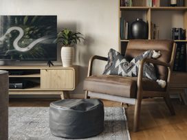 A living room with an armchair and television at Rydal Apartment Ambleside