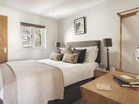 A bedroom with a bed, nightstand, and window at Rydal Apartment Ambleside