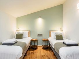 A bedroom with two single beds and round wooden side tables at Keldy Golden Oak in Keldy Forest