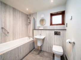 A bathroom with a bathtub shower sink toilet and small window at Glentress Forest Golden Oak Treehouse Glentress Forest Peebles