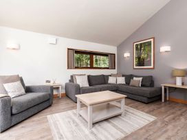 A living room with gray sofas a wooden coffee table and framed wall art at Keldy White Willow Premium in Keldy Forest