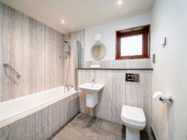 A bathroom with a bathtub shower sink toilet and window at Strathyre Golden Oak Treehouse in Strathyre Ben Ledi