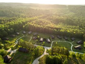 An aerial view of cabins arranged in a circle surrounded by dense forest at Cropton Golden Oak in Cropton Forest