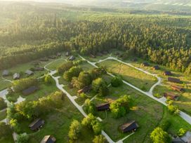 An aerial view of cabins surrounded by trees and pathways in a forested area at Cropton Golden Oak in Cropton Forest