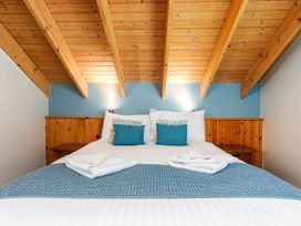 A bedroom with a bed and wooden beams at Strathyre Classic Silver Birch in Strathyre, Ben Ledi