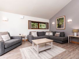 A living room with gray sofas a wooden coffee table a window and a framed picture at Glentress Forest White Willow Premium in Glentress Forest Peebles