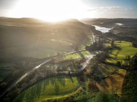 An aerial view of a landscape with a river a road trees and green fields at Glentress Forest Golden Oak Hideaway Glentress Forest Peebles