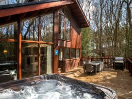 An outdoor area with a hot tub and dining set at Delamere Forest Golden Oak Delamere Forest