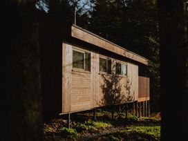 A wooden cabin on stilts among trees in a forest Glentress The Unfurl Cabin 2 Bed Glentress Forest Peebles