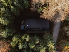 An aerial view of a cabin surrounded by trees and a driveway at Glentress The Unfurl Cabin (2 Bed) Glentress Forest Peebles