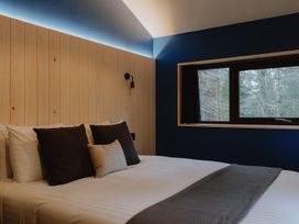 A bedroom with a bed and pillows next to a window at Glentress The Unfurl Cabin 2 Bed in Glentress Forest Peebles