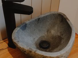 A stone sink with a black faucet on a wooden surface at Glentress The Unfurl Cabin (2 Bed) Glentress Forest Peebles