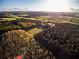 Aerial view of forest patches and open fields with some buildings in the distance at Sherwood Forest Golden Oak Hideaway Sherwood Forest