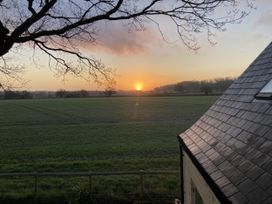A sunset view over a field with a tree and roof at 4 Wellacres Cottage Draycott near Moreton-In-Marsh