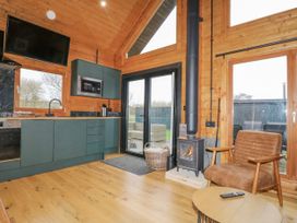 A kitchen with a dining area and wood stove at Squirrel's Nest in South Luffenham near Edith Weston