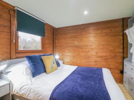 A bedroom with a bed and window at Squirrel's Nest South Luffenham near Edith Weston
