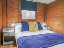 A bedroom with bed and bedside tables at Squirrel's Nest in South Luffenham near Edith Weston