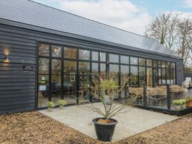 An exterior view of a reception building with seating and planters at Squirrel's Nest in South Luffenham near Edith Weston