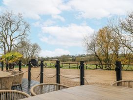 An outdoor area with a table and chairs overlooking a landscape at Squirrel's Nest South Luffenham near Edith Weston