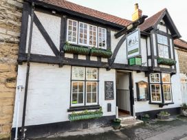 Front of a pub with white and black timber walls with flower boxes and a sign that reads The Royal Oak Pub Old Malton Old Malton near Malton