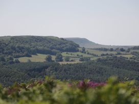 A rural landscape with rolling hills trees and fields at Millers Cottage in Old Malton near Malton