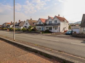 A row of houses along a street with a parked blue car and a streetlamp in Seaward Rhos-On-Sea