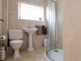 A bathroom with a toilet sink shower and towels at Seaward in Rhos-On-Sea
