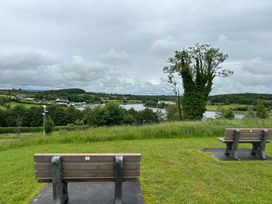 A view of a lake and benches at 30 River Run in Belturbet